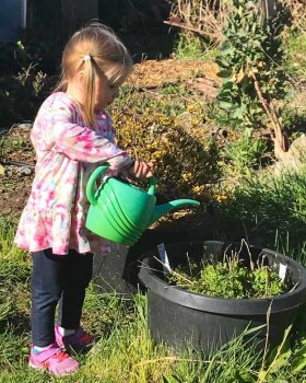 Adorable granddaughter watering plants