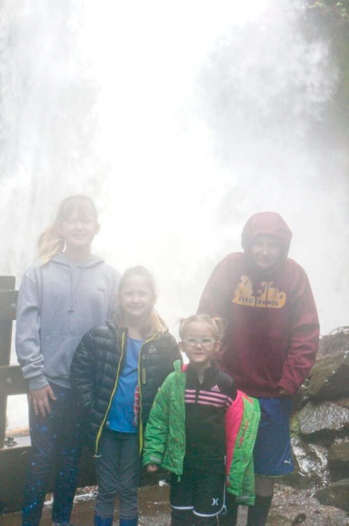 Kids getting drenched by waterfall mist