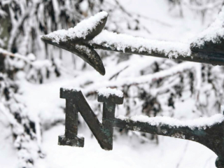 True North Weather vane pointing North covered in snow
