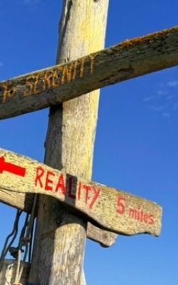 Signpost: "Welcome to Serenity" and "Reality 5 miles" in the other direction.